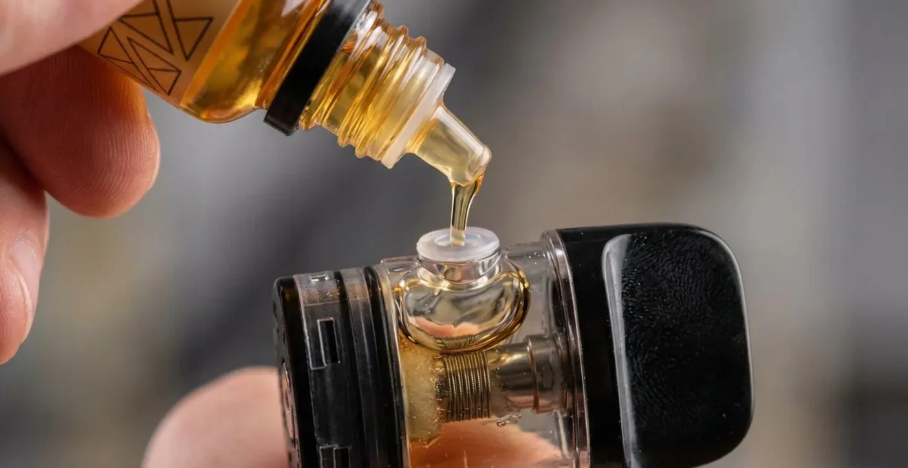 Mains remplissant délicatement un pod de cigarette électronique avec technique appropriée